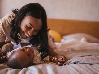 La mamá y el bebé haciendo ejercicios en la cama