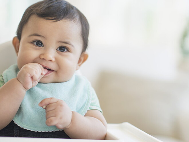 Bebé de 9 meses sentado sonriendo