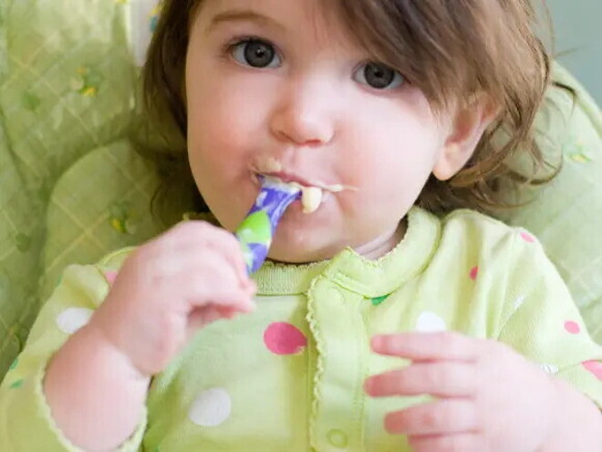 Niña comiendo con cubiertos