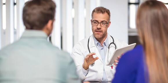 Padres revisando con el médico las ayudas médicas para la dilatación.