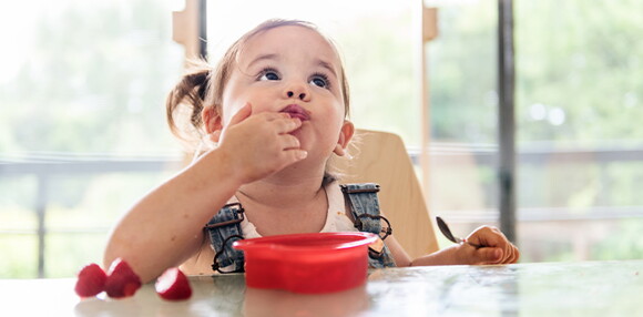 Niña comiendo fresa. 