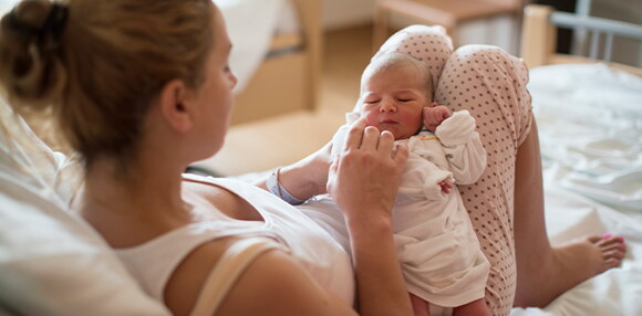 Mamá alzando a su bebé y revisando los granitos en la cara